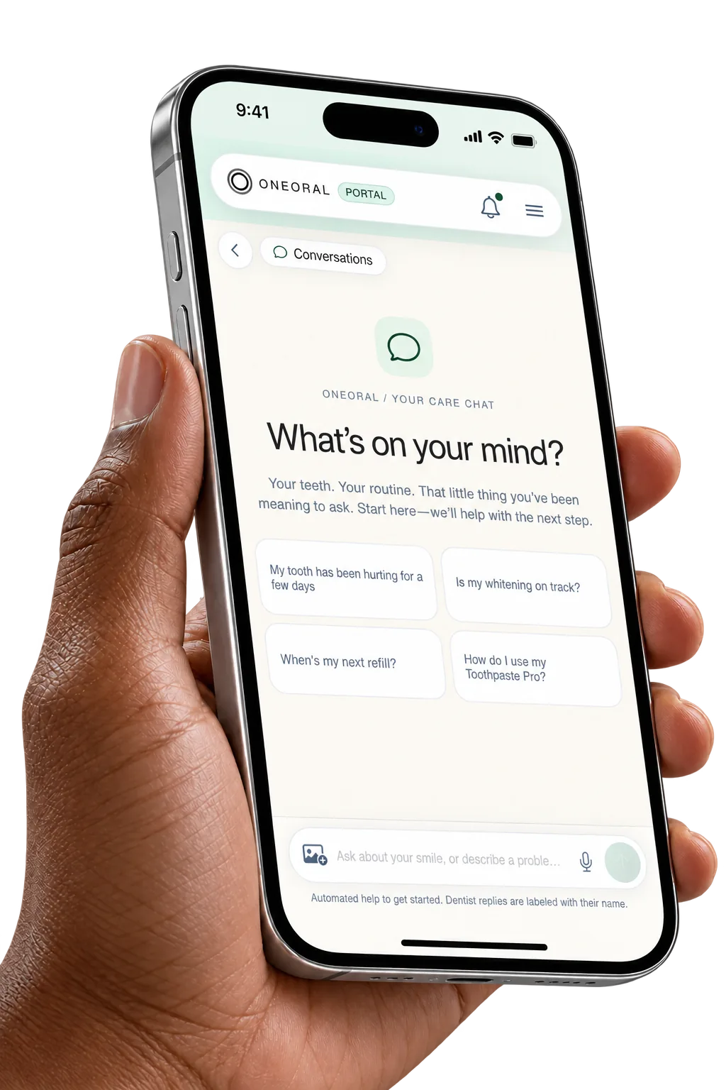 A brown hand holds a silver phone showing the OneOral portal care-chat welcome screen and suggested questions