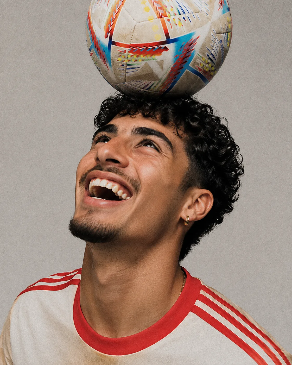 A footballer balancing a ball on their head